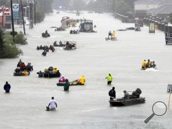 Rescue boats fill a flooded street as flood victims are evacuated as floodwaters from Tropical Storm Harvey rise Monday, Aug. 28, 2017, in Houston. (AP Photo/David J. Phillip)