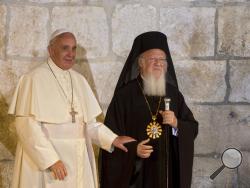 FILE - In this May 25, 2014 file photo, Pope Francis stands with Ecumenical Patriarch Bartholomew I as they meet outside the Church of the Holy Sepulchre, in Jerusalem's Old City. Pope Francis and the spiritual leader of the world's Orthodox Christians are urging political leaders to "support the consensus of the world" that climate change and other environmental ills have created an ecological crisis that is harming the world's poorest the most. Christianity's top spiritual leaders issued the joint appeal 