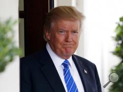 President Donald Trump waits outside the West Wing of the White House for the arrival of Malaysian Prime Minister Najib Razak, Tuesday, Sept. 12, 2017, in Washington. ESPN distanced itself from anchor Jemele Hill's tweets one day after she called Trump "a white supremacist" and "a bigot." (AP Photo/Evan Vucci)