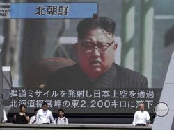 People walk past a public TV screen showing a file footage of North Korean leader Kim Jong Un during news on North's missile launch, in Tokyo, Friday, Sept. 15, 2017. North Korea fired an intermediate-range missile over Japan into the northern Pacific Ocean on Friday, U.S. and South Korean militaries said, its longest-ever such flight and a clear message of defiance to its rivals. (AP Photo/Eugene Hoshiko)