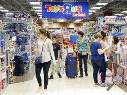 FILE - In this Friday, Nov. 25, 2016, file photo, shoppers shop in a Toys R Us store on Black Friday in Miami. Toys R Us, the pioneering big box toy retailer, announced late Monday, Sept. 18, 2017 it has filed for Chapter 11 bankruptcy protection while continuing with normal business operations. (AP Photo/Alan Diaz, File)