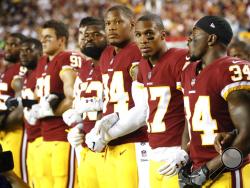 Member of the Washington Redskins stand arm in arm during the playing of the National Anthem before an NFL football game against the Oakland Raiders in Landover, Md., Sunday, Sept. 24, 2017. (AP Photo/Pablo Martinez Monsivais)