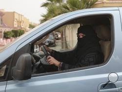 FILE- In this Saturday, March 29, 2014 file photo, a woman drives a car in Riyadh, Saudi Arabia, as part of a campaign to defy Saudi Arabia's ban on women driving. Saudi Arabia authorities announced Tuesday Sept. 26, 2017, that women will be allowed to drive for the first time in the ultra-conservative kingdom from next summer, fulfilling a key demand of women's rights activists who faced detention for defying the ban. (AP Photo/Hasan Jamali, FILE)