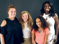 In this Tuesday, Sept. 26, 2017 photo, from left, Maria and Kylie DeLuca, of Henryville, Pa., pose with Laci and Caroline Verkaik, of Marshalls Creek, Pa., in Stroudsburg, Pa. Kylie and Laci were briefly switched at birth before being reunited with their correct families at a New Jersey hospital. By chance the two families crossed paths a second time after they both moved to the Poconos. (Keith R. Stevenson /Pocono Record via AP)