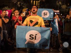 Independence supporters gather in Barcelona's main square, Spain, Sunday, Oct. 1, 2017. Authorities say 844 people and 33 police were injured Sunday in Spanish police raids to halt the independence vote organized by the Catalan autonomous government that was declared ilegal by Spain's constitutional court. (AP Photo/Santi Palacios)