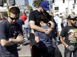 Reed Broschart, center, hugs his girlfriend Aria James on the Las Vegas Strip in the aftermath of a mass shooting at a concert Monday, Oct. 2, 2017, in Las Vegas. The couple, both of Ventura, Calif., attended the concert. (AP Photo/Marcio Jose Sanchez)