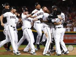 The Arizona Diamondbacks celebrate after the National League wild-card playoff baseball game against the Colorado Rockies, Wednesday, Oct. 4, 2017, in Phoenix. The Diamondbacks won 11-8 to advance to an NLDS against the Los Angeles Dodgers. (AP Photo/Matt York)