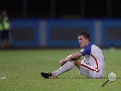 United States' Matt Besler, sits on the pitch after losing 2-1 against Trinidad and Tobago during a 2018 World Cup qualifying soccer match in Couva, Trinidad, Tuesday, Oct. 10, 2017. (AP Photo/Rebecca Blackwell)