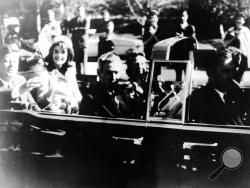 This image provided by the Warren commission, shows Warren Commission Exhibit No. 697, President John F. Kennedy at the extreme right on rear seat of his limousine during Dallas, motorcade on Nov. 22, 1963. His wife, Jacqueline, beside him, Gov. John Connally of Texas and his wife were on jump seats in front of the president. President Donald Trump is caught in a push-pull on new details of Kennedy’s assassination, jammed between students of the killing who want every scrap of information and intelligence a