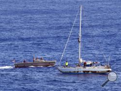 In this Wednesday, Oct. 25, 2017 photo, sailors from the USS Ashland approach a sailboat with two Honolulu women and their dogs aboard as they are rescued after being lost at sea for several months while trying to sail from Hawaii to Tahiti. The U.S. Navy rescued the women on Wednesday after a Taiwanese fishing vessel spotted them about 900 miles southeast of Japan on Tuesday and alerted the U.S. Coast Guard. The women, identified by the Navy as Jennifer Appel and Tasha Fuiaba, lost their engine in bad weat