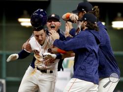 The Houston Astros celebrate after Alex Bregman (2) game winning single during Game 5 of baseball's World Series against the Los Angeles Dodgers Monday, Oct. 30, 2017, in Houston. Astros won 13-12. (AP Photo/Matt Slocum)