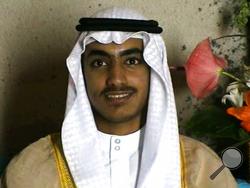 In this image from video released by the CIA, Hamza bin Laden is seen as an adult at his wedding. The never-before-seen video of Osama bin Laden's son and potential successor was released Nov. 1, 2017, by the CIA in a trove of material recovered during the May 2011 raid that killed the al-Qaida leader at his compound in Pakistan. The one hourlong video shows Hamza bin Laden, sporting a trimmed mustache but no beard, at his wedding. He is sitting on a carpet with other men. (CIA via AP)