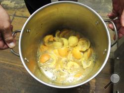 Gregory Sacavage, of Mount Carmel, Pa., cooks a batch of boilo while teaching others how to make the beverage on Friday, Dec. 1, 2017. During the boilo-making process, oranges, lemons and a variety of spices are left to simmer in a pot so flavors can meld together. (Sarah DeSantis/The News-Item via AP)