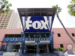 FILE - In this Tuesday, May 7, 2013, file photo, an entrance to a parking garage at 20th Century-Fox studios, an entity owned by News Corporation, is seen in Los Angeles. Disney announced Thursday, Dec. 14, 2017, that it is buying a large part of Fox, but the Fox studio lot in Los Angeles will remain with the Murdoch family. (AP Photo/Reed Saxon, File)