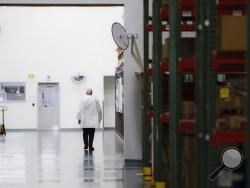In this Oct. 24, 2017, photo, an employee walks off the manufacturing floor while wearing his laboratory coat at Lord Corporation, a manufacturer of industrial coatings, adhesives, bearings, and sensing equipment for range of commercial markets, including United States military contracts in Erie, Pa. Since 2008, Erie has suffered a hidden and potentially more devastating exodus: The loss of well-paid white-collar jobs. The city has shed 8 percent of its accountants, 10 percent of its computer workers, 40 pe