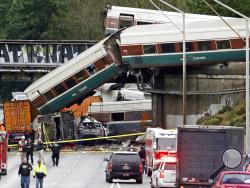 Cars from an Amtrak train lay spilled onto Interstate 5 below alongside smashed vehicles as some train cars remain on the tracks above Monday, Dec. 18, 2017, in DuPont, Wash. The Amtrak train making the first-ever run along a faster new route hurtled off the overpass Monday near Tacoma and spilled some of its cars onto the highway below, killing some people, authorities said. Seventy-eight passengers and five crew members were aboard when the train moving at more than 80 mph derailed about 40 miles south of