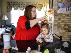 In this Dec. 4, 2017 photo, Joanne gets her granddaughter Carter ready for daycare in Camp Hill, Pa. Joanne Clough, 60, is raising her granddaughter Carter Gens since Carter's mother died of a fentanyl overdose last year. Clough's daughter Emily Roznowski, the mother of Carter, died on Dec. 3, 2016. (Dan Gleiter /PennLive.com via AP)