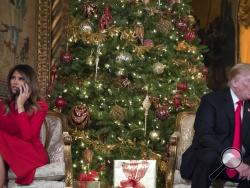 President Donald Trump and first lady Melania Trump speak on the phone with children as they track Santa Claus' movements with the North American Aerospace Defense Command (NORAD) Santa Tracker on Christmas Eve at the president's Mar-a-Lago estate in Palm Beach, Fla., Sunday, Dec. 24, 2017. (AP Photo/Carolyn Kaster)
