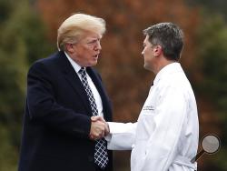 President Donald Trump shakes hands with White House physician Dr. Ronny Jackson as he boards Marine One as he leaves Walter Reed National Military Medical Center in Bethesda, Md., Friday, Jan. 12, 2018, after his first medical check-up as president. (AP Photo/Carolyn Kaster)