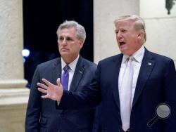 President Donald Trump, right, accompanied by House Majority Leader Kevin McCarthy, R-Calif., speaks to members of the media as they arrive for a dinner at Trump International Golf Club in West Palm Beach, Fla., Sunday, Jan. 14, 2018. (AP Photo/Andrew Harnik)