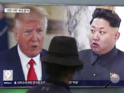 FILE - In this Aug. 10, 2017, file photo, a man watches a television screen showing U.S. President Donald Trump and North Korean leader Kim Jong Un during a news program at the Seoul Train Station in Seoul, South Korea. North Korea's state-run media say U.S. President Donald Trump's tweet about having a bigger nuclear button than Kim Jong Un's is the "spasm of a lunatic." (AP Photo/Ahn Young-joon, File)