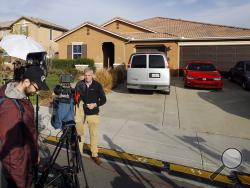 Members of the media work outside a home Tuesday, Jan. 16, 2018, where police arrested a couple on Sunday accused of holding their 13 children captive, in Perris, Calif. Authorities said an emaciated teenager led deputies to the California home where her 12 brothers and sisters were locked up in filthy conditions, with some of them malnourished and chained to beds. (AP Photo/Alex Gallardo)