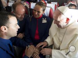 Pope Francis marries flight attendants Carlos Ciuffardi, left, and Paola Podest, center, during a flight from Santiago, Chile, to Iquique, Chile, Thursday, Jan. 18, 2018. Pope Francis celebrated the first-ever airborne papal wedding, marrying these two flight attendants from Chile’s flagship airline during the flight. The couple had been married civilly in 2010, however, they said they couldn’t follow-up with a church ceremony because of the 2010 earthquake that hit Chile. (L'Osservatore Romano Vatican Medi