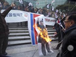 South Korean protesters burn a portrait of North Korean leader Kim Jong Un during a rally against a visit of North Korean Hyon Song Wol, head of a North Korean art troupe, in front of Seoul Railway Station in Seoul, South Korea, Monday, Jan. 22, 2018. Dozens of conservative activists have attempted to burn a large photo of North Korean leader Kim Jong Un as the head of the North's hugely popular girl band passed by them at a Seoul railway station. (AP Photo/Ahn Young-joon)
