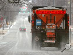 FILE - In this Jan. 16, 2017 file photo, a city truck spreads salt on Q Street in Lincoln, Neb. Scientists are starting to raise concerns about road salt's impact on the environment, especially drinking water, because lakes and streams near roads are showing elevated levels of sodium and chloride. (Eric Gregory/The Journal Star via AP, File)