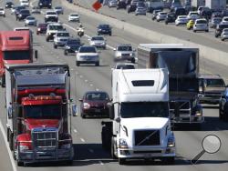 FILE - In this Aug. 24, 2016, file photo, truck and automobile traffic mix on Interstate 5, headed north through Fife, Wash., near the Port of Tacoma. President Donald Trump’s plan to beef up the nation’s infrastructure will contain a crater-sized hole when it’s unveiled next month. The trust fund that pays for most federal highway and transit aid is forecast to go broke in about three years unless the government significantly scales back its transportation spending or comes up with more money.(AP Photo/Ted