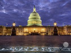 FILE - In this Jan. 21, 2018, file photo, lights shine inside the U.S. Capitol Building as night falls in Washington. President Donald Trump will herald a robust economy and push for bipartisan congressional action on immigration in his Jan. 30, State of the Union address. The speech marks the ceremonial kick-off of Trump’s second year in office and is traditionally a president’s biggest platform to speak to the nation. (AP Photo/J. David Ake, File)