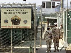 In this June 27, 2006 file photo, reviewed by a U.S. Department of Defense official, U.S. military guards walk within Camp Delta military-run prison, at the Guantanamo Bay U.S. Naval Base, Cuba. (AP Photo/Brennan Linsley, File)