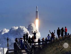 The crowd cheers at Playalinda Beach in the Canaveral National Seashore, just north of the Kennedy Space Center, during the successful launch of the SpaceX Falcon Heavy rocket, Tuesday, Feb. 6, 2018. Playalinda is one of closest public viewing spots to see the launch, about 3 miles from the SpaceX launchpad 39A. (Joe Burbank/Orlando Sentinel via AP)