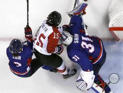 Rui Ukita (15), of Japan, battles for the puck against South Korea's Eom Suyeon (3) and South Korea's goalie Shin So-jung (31), of the combined Koreas team, during the first period of the preliminary round of the women's hockey game at the 2018 Winter Olympics in Gangneung, South Korea, Wednesday, Feb. 14, 2018. (AP Photo/Frank Franklin II)