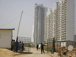 A security man closes a gate leading to the proposed site for the Trump Towers in Gurgaon, a suburb of New Delhi, India, Tuesday, Feb. 20, 2018. The eldest son of U.S. President Donald Trump has arrived in India to help sell luxury apartments and lavish attention on wealthy Indians who have already bought units in a string of Trump-branded developments. (AP Photo/Altaf Qadri)