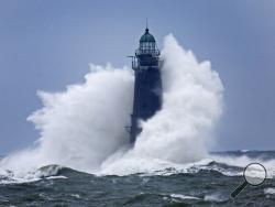 Waves crash against Minot Light off the Scituate coast off Massachusetts, Sunday, March 4, 2018 as a large nor'easter that hit over the weekend continues to batter the coast. The 89-foot-tall lighthouse was built in 1855. (Greg Derr/The Quincy Patriot Ledger via AP)