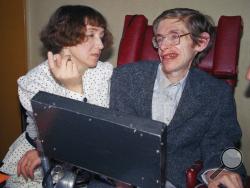 FILE - In this March 3, 1989 file photo British astrophysicist Dr. Stephen Hawking, 47, answers newsmen with the help of his computer and the assistance of his then wife Jane, in Paris. Hawking, who has a motor neuron disease communicates with the help of a voice-equipped computer. Hawking, whose brilliant mind ranged across time and space though his body was paralyzed by disease, has died, a family spokesman said early Wednesday, March 14, 2018. (AP Photo/Lionel Cironneau, File)