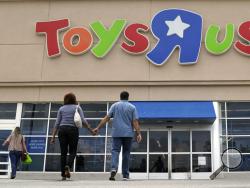 FILE - In this Tuesday, Sept. 19, 2017, photo, shoppers walk into a Toys R Us store, in San Antonio. Toys R Us's management has told its employees that it will sell or close all of its U.S. stores. The 70-year-old retailer is headed toward shuttering its U.S. operations, jeopardizing the jobs of some 30,000 employees while spelling the end for a chain known to generations for its sprawling stores and Geoffrey the giraffe mascot. The closing of the company's 740 U.S. stores will finalize the downfall of the 