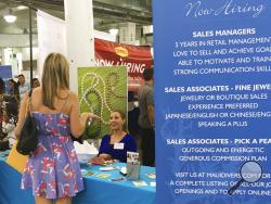 In this Jan. 31, 2018 photo, a woman speaks to Maui Divers Jewelry representatives at a job fair in Honolulu. Recently released numbers show Hawaii boasts the United States' lowest jobless rate, at 2.1 percent. But experts say the figure is masking underlying problems. (AP Photo/Audrey McAvoy)