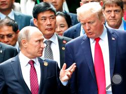 FILE - In this Nov. 11, 2017, file photo, President Donald Trump, right, and Russia President Vladimir Putin talk during the family photo session at the APEC Summit in Danang. The Trump administration is opening the door to a potential White House meeting between Trump and Putin. It would be the first time Putin has been at the White House in more than a decade and come at a time of rising tensions between the two global powers. (Mikhail Klimentyev, Sputnik, Kremlin Pool Photo via AP)
