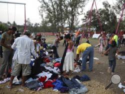Central American migrants participating in the Migrant Stations of the Cross caravan search through donated clothing during the caravan's few-day's stop at a sports center in Matias Romero, Oaxaca state, Mexico, late Monday, April 2, 2018. The annual caravans have been held in southern Mexico for years as an Easter-season protest against the kidnappings, extortion, beatings and killings suffered by many Central American migrants as they cross Mexico. (AP Photo/Felix Marquez)