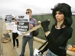 This Aug. 12, 2009, photo shows Nasim Aghdam, right, as she joins members of People for the Ethical for Animals, PETA, protesting at the main gate of Marine Corps base Camp Pendleton in Oceanside, Calif., against the Marine's killings of pigs in a military exercise. Law enforcement officials have identified Nasim Aghdam as the person who opened fire with a handgun Tuesday, April 3, 2018, at YouTube headquarters in San Bruno, Calif., wounding several people before fatally shooting herself. (Charlie Neuman/Th