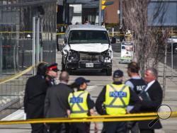 Police are seen near a damaged van after a van mounted a sidewalk crashing into pedestrians in Toronto on Monday, April 23, 2018. The van apparently jumped a curb Monday in a busy intersection in Toronto and struck the pedestrians and fled the scene before it was found and the driver was taken into custody, Canadian police said. (Aaron Vincent Elkaim/The Canadian Press via AP)