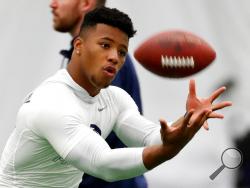 File-This March 20, 2018, file photo shows running back Saquon Barkley catching a football during Penn State NFL football Pro Day in State College, Pa. Barkley is the best player in this year's draft. Yet he might not go in the first handful of picks Thursday night. Huh? Blame the desperation to find quarterbacks in great part for the possibility that the Penn State All-America running back could fall well below where his talent, character and versatility warrant. (AP Photo/Gene J. Puskar, File)