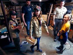 FILE - In this March 1, 2018, file photo, Tatum Weir, center, carries a tool box she built as her twin brother Ian, left, follows after a Cub Scout meeting in Madbury, N.H. Fifteen communities in New Hampshire are part of an "early adopter" program to allow girls to become Cub Scouts and eventually Boy Scouts. For 108 years, the Boy Scouts of America's flagship program for older boys has been known simply as the Boy Scouts. With girls soon entering the ranks, the BSA says that iconic name will change to “Sc