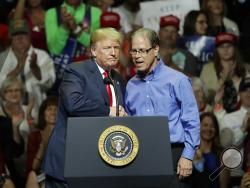 President Donald Trump, left, and Indiana Republican senatorial candidate Mike Braun embrace during a GOP campaign rally Thursday, May 10, 2018, in Elkhart, Ind. (AP Photo/Charles Rex Arbogast)