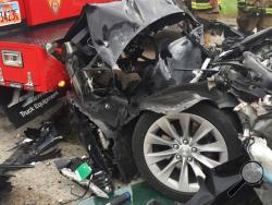 FILE -In this Friday, May 11, 2018, file photo released by the South Jordan Police Department shows a traffic collision involving a Tesla Model S sedan with a Fire Department mechanic truck stopped at a red light in South Jordan, Utah. The driver of a Tesla electric car that hit a Utah fire department vehicle over the weekend says the car's semi-autonomous Autopilot mode was engaged at the time of the crash. Police in the Salt Lake City suburb of South Jordan said Monday, May 14, 2018, the driver also said 