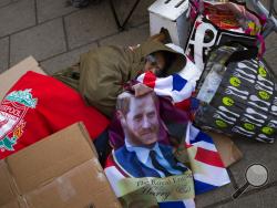 A man sleeps on the ground, spending the night near Windsor castle, England, Friday, May 18, 2018. Preparations continue in Windsor ahead of the royal wedding of Britain's Prince Harry and Meghan Markle Saturday, May 19. (AP Photo/Emilio Morenatti)