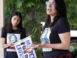Christina Delgado, right, talks about the school shooting as her daughter, London, listens Sunday, May 20, 2018, in Santa Fe, Texas. Delgado watched in horror last week as the extreme gun violence she had marched to prevent arrived in her town. A gunman opened fire inside Santa Fe High School on Friday, killing 10 people. (AP Photo/David J. Phillip)