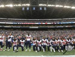FILE - In this Oct. 29, 2017, file photo, Houston Texans players kneel and stand during the singing of the national anthem before an NFL football game against the Seattle Seahawks, in Seattle. NFL owners have approved a new policy aimed at addressing the firestorm over national anthem protests, permitting players to stay in the locker room during the "The Star-Spangled Banner" but requiring them to stand if they come to the field. The decision was announced Wednesday, May 23, 2018, by NFL Commissioner Roger